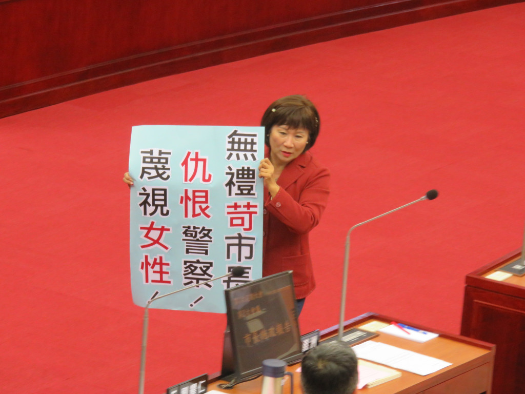 台北市長柯文哲今天赴議會施政報告，中國國民黨議員厲耿桂芳除舉牌抗議外，還高唱黃梅調諷柯是皇帝。(記者林冠妙攝20150414)