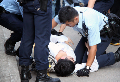 香港警方25日在旺角「占中」占領地進行清場，有示威者被武力制服後暈倒，由警員急救。(中央社)