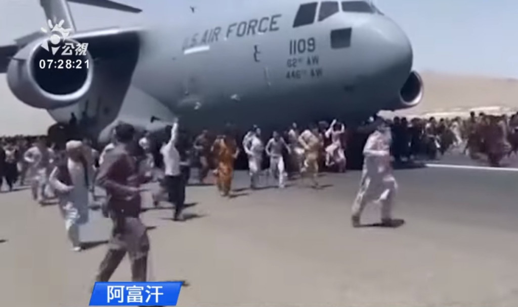 美國空軍C-7運輸機在喀布爾國際機場起飛時，阿富汗上百人在跑道上跟隨奔跑。圖／擷自公視新聞影片