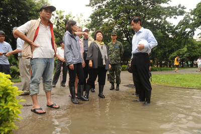 高雄市長陳菊昨(8日)一早勘查淹水情形，對於氣爆災區雨水系統已被炸損卻又遇大雨造成淹水，一臉愁容。(中央社)