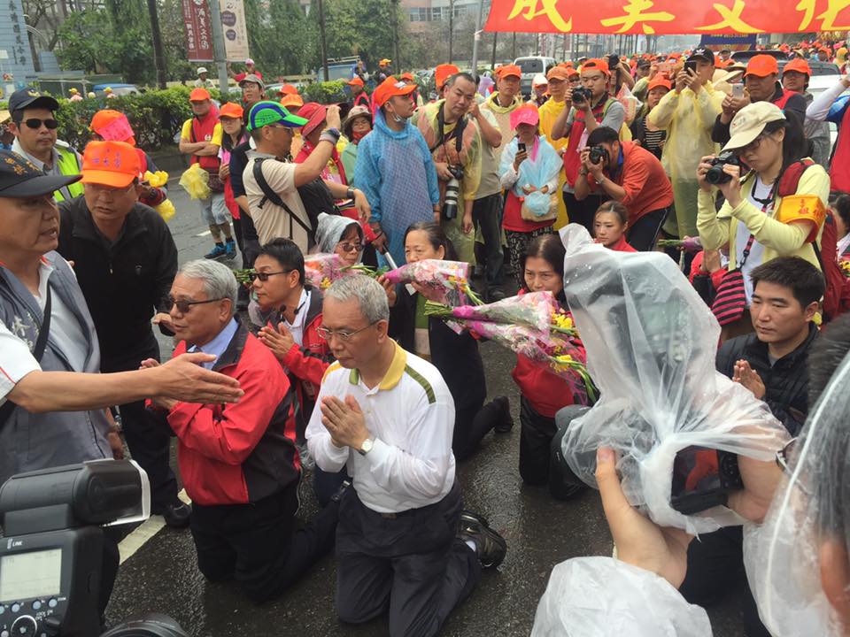 頂新集團高層一早在彰化永靖鄉成美園區附近擺設香案等候媽祖到來，但頂新魏應交與魏應充等人虔誠想要「鑽轎腳」，卻換得媽祖從旁快閃，一臉尷尬。（圖片擷取自地方人世林滄淵臉書）