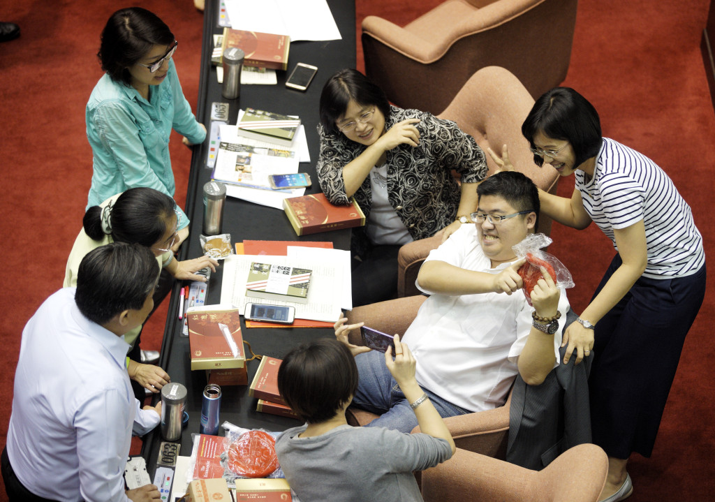 立法院院會今天進行不當黨產條例表決大戰，民進黨立委憑著優勢人力，好整以暇，氣氛愉快的拿著紅龜粿玩自拍；而國民黨立委則在議場後方圍成一圈，表情凝重的進行攻防推演。圖/張良一