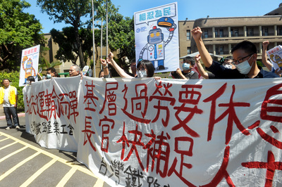 台鐵產業工會數十人在台北車站發動靜坐活動，16日從車站，拉著「為公共運輸而戰」訴求布條，步行至行政院，呼口號要求台鐵對人力不足、輪班制度具體改善。圖/中央社