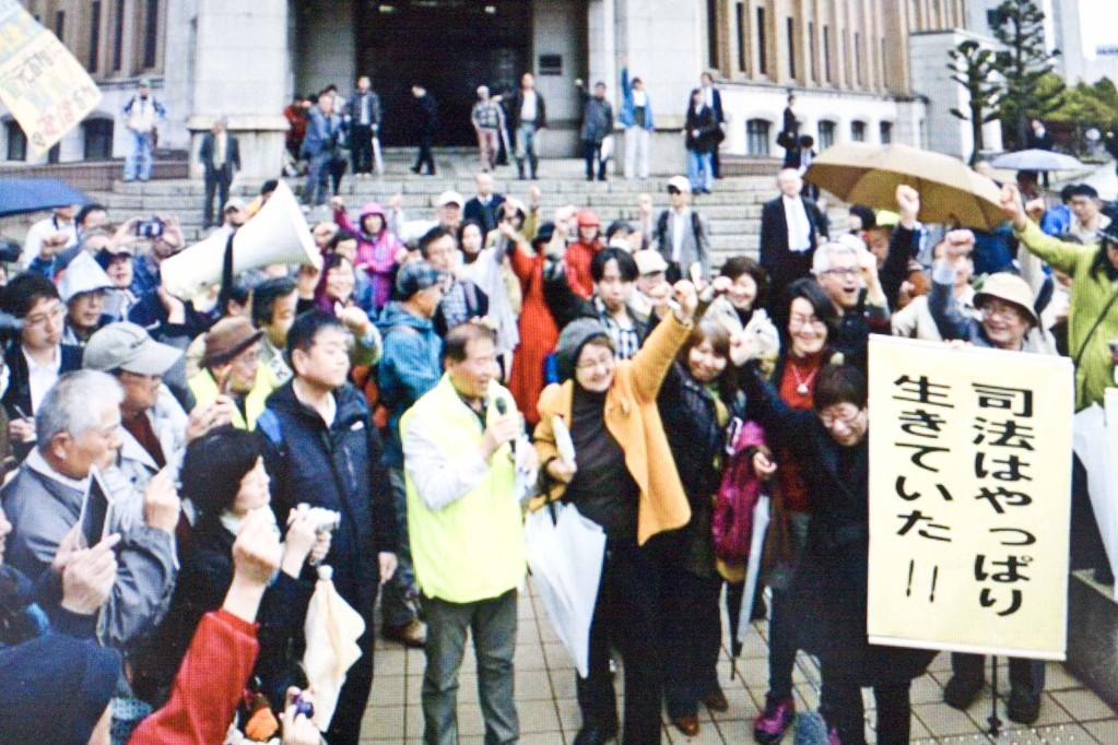 法官裁定後，福井居民委任律師在地方法院前朗讀聲明指出，這次的凍核裁定，是推動零核電的歷史性一步（共同社網路圖片翻攝）