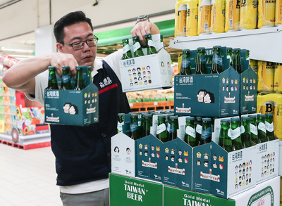 蔡英文總統就職紀念啤酒今日在量販店通路上架販售，內湖大潤發工作人員一早就忙著把小英啤酒上架，但不久隨即被民眾搶購一空。（中央社）