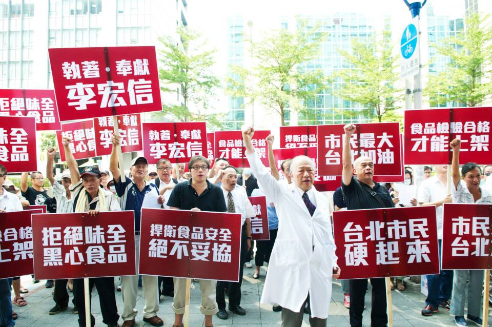無黨籍的台北市長參選人李宏信(中穿白袍者)今日與近百民眾，至味全總公司前抗議。(記者黃謙賢攝)