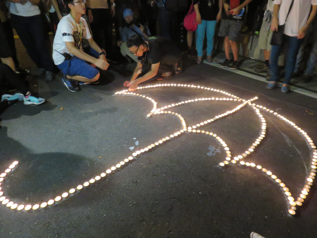 反黑箱課綱學生，22日晚間夜宿教育部，舉行燭光祈福活動，哀悼已死的教育魂，用蠟燭排出雨傘形狀，「點燃希望，照亮黑箱！」。（記者林冠妙攝20150722）