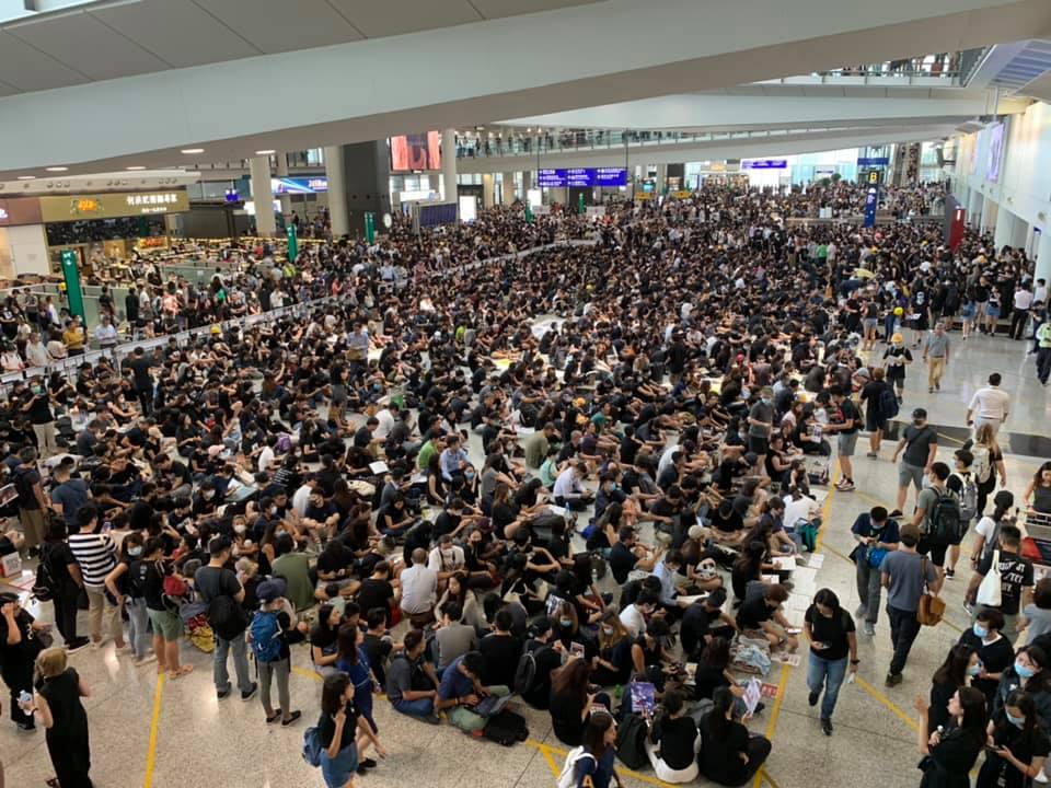 香港警民衝突升高，一名女子11日在示威中遭警方射傷右眼，圖為12日港民於機場靜坐，要求「黑警還眼」、「五大訴求，缺一不可」。圖／香港大學學生會學苑即時新聞臉書