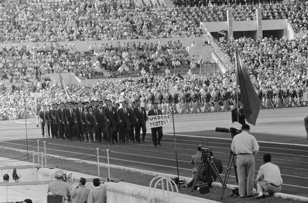 羅馬奧運時，台灣「被要求以Taiwan名稱參賽」，結果在手持「抗議」字樣的牌子下進場。當時如能借力使力，為台灣正名，也不會淪落成今天不倫不類的「中華台北」了。圖為1960年羅馬奧運，開幕典禮上的「台灣」代表團，林鴻坦舉著「UNDER PROTEST」的白色橫幅。圖／擷自維基百科，公有領域