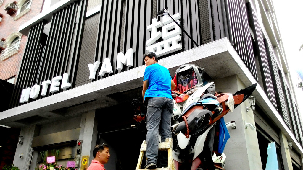 「Hotel Yam塩旅社」團隊代表人謝銘仁以由新營「萬里綠」資源回收場員工阿發利用回收材料組裝成的機器人做為迎賓揭幕(記者陳俊廷攝)