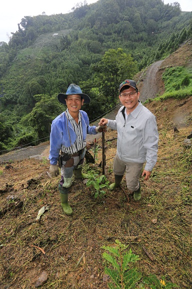 林佳龍在「樹王」賴桑指導下，種下一棵台灣本土原生種珍木牛樟，並取名「希望之樹」。（中市新聞局提供）
