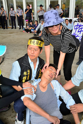 台化員工6日再度出動千人包圍彰化縣府，員工與維持秩序的員警發生衝突，混亂中有員工昏厥，等待送醫。(圖／中央社)