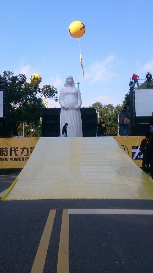 雕塑家李良仁一座10公尺高的年輕孕母雕塑像,矗立時代力量今晚造勢場合,象徵社會大眾對新政黨、新政治的期許。(時代力量提供)