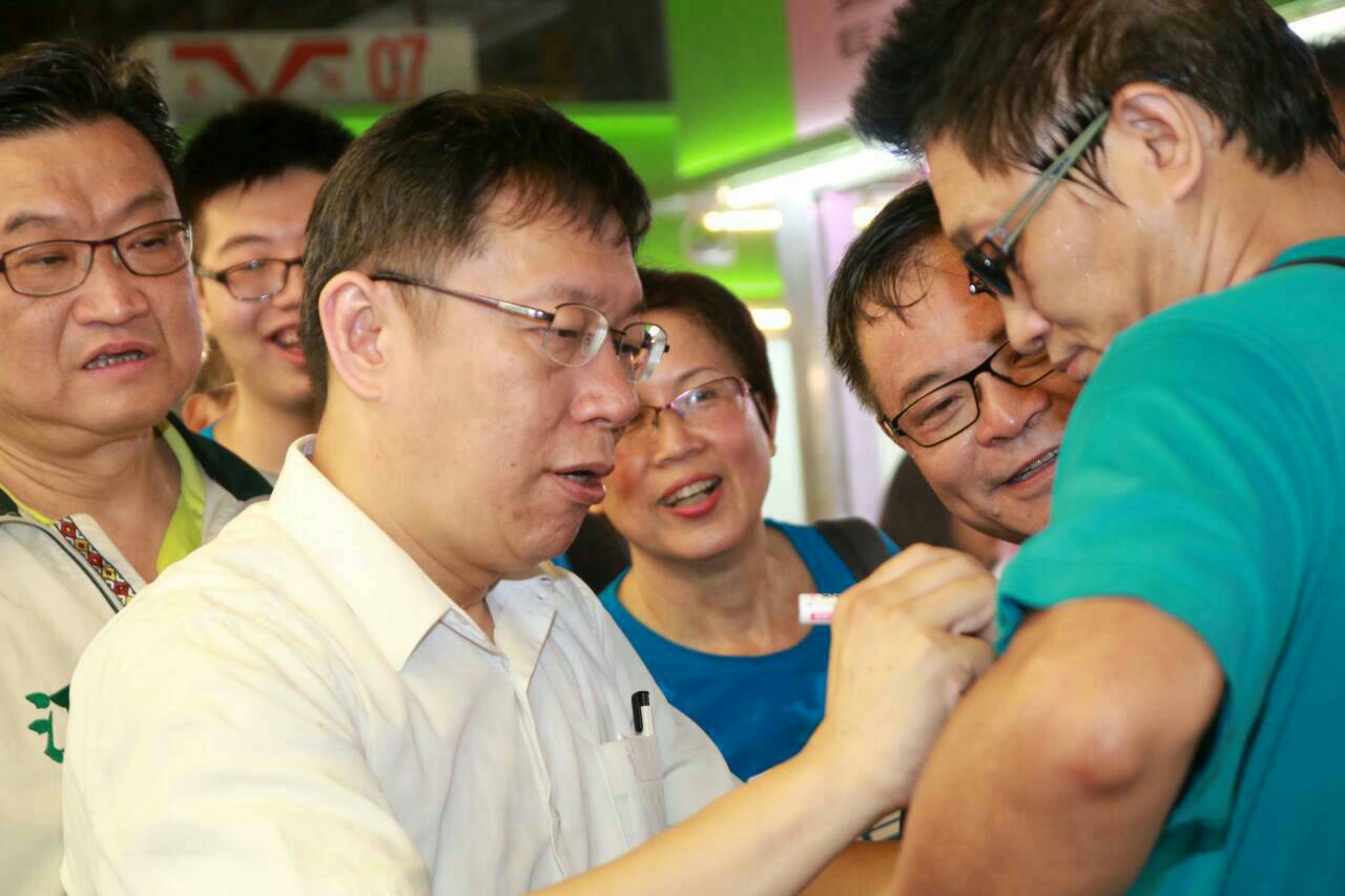 台北市長參選人柯文哲今天（6日）上午到內湖花卉市場拜票，遇到支持者要求在衣服上簽名。（柯文哲辦公室提供）