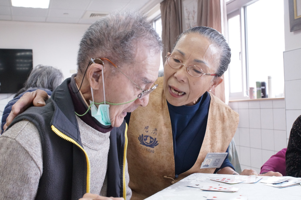 李金寶阿嬤(右）樂當醫療志工服務病患。圖/大林慈濟醫院提供