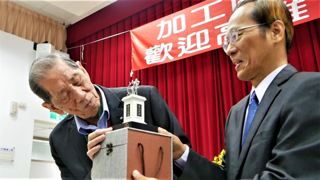 加工處長黃文谷致贈歷史地標「時代巨輪」模型給時任高雄電子總經理葉守璋(左)。(圖/陳俊廷)