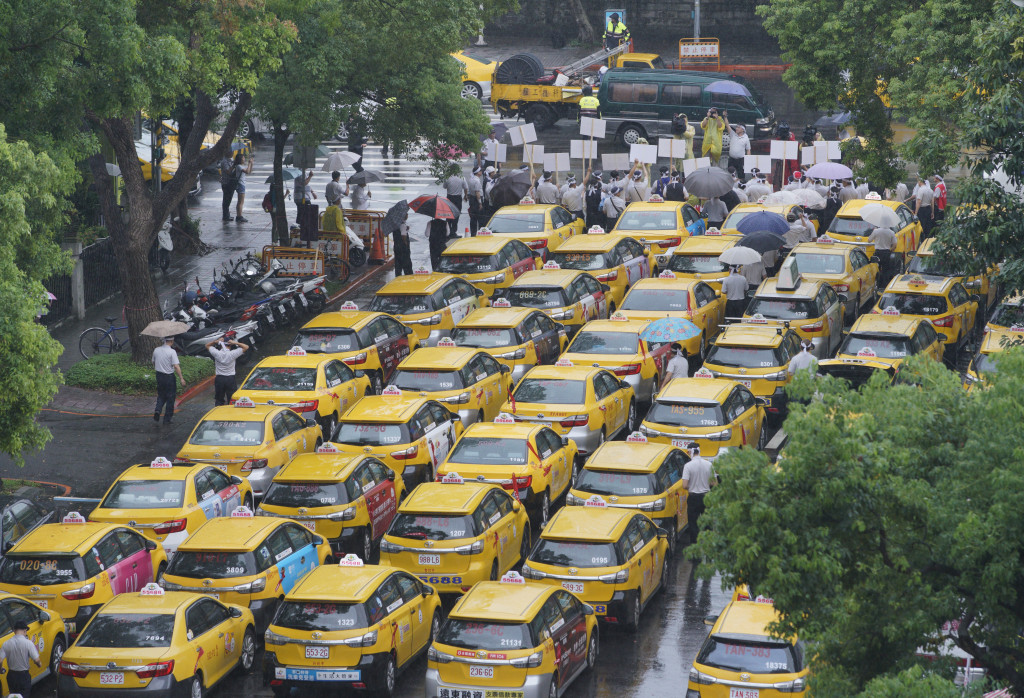 政府終於決定要對UBER下重手，修法重罰2500萬元。圖為7月間近千名計程車司機在立院外，抗議政府任由UBER違法在台營業。張良一攝（資料照片）