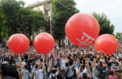 數千名同志與公民團體支持者，5日在立法院外舉行彩虹圍城行動，與會群眾將4顆象徵婚姻平權的紅色大球，一顆顆推進立法院，要求立委接住人民的訴求。（中央社）