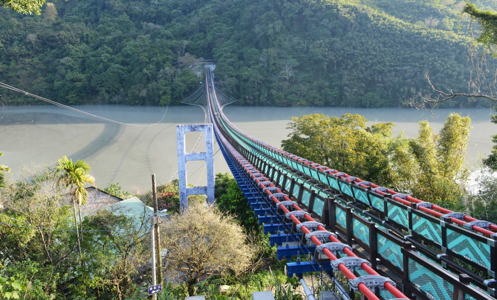 站在紅綠相間的吊橋，眼前風景壯麗，但長達303公尺，也讓許多遊客不敢回頭。圖／桃園市政府