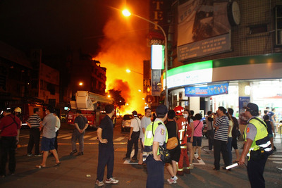 高雄市前鎮區氣爆傷亡慘重，現場有如戰地，警消漏夜搶救L，民代投入服務，民眾也互助協助搬運傷患。(中央社)