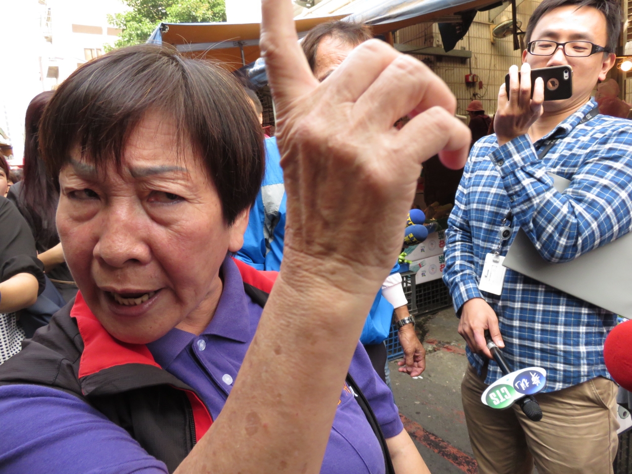 柯文哲長春市場掃街,有藍軍支持者抗議柯竊聽自導自演。(朱蒲青攝)