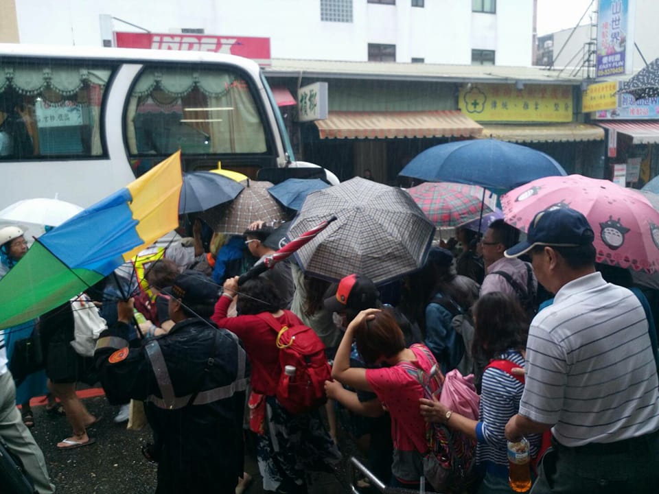 中部地區今天遭豪雨侵襲，台鐵多個路段遭水淹，緊急啟動公車接駁，民眾冒雨排隊搭乘。(圖/擷取自fun台鐵臉書)