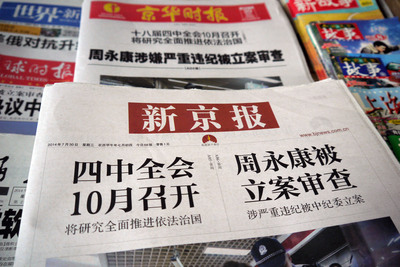 中國多份報刊如新京報、京華時報30日頭版都是「周永康涉嫌嚴重違紀被立案審查」，加粗黑體字的大標醒目，內容完全照登新華社69字的短稿。圖為北京書報攤。（中央社）