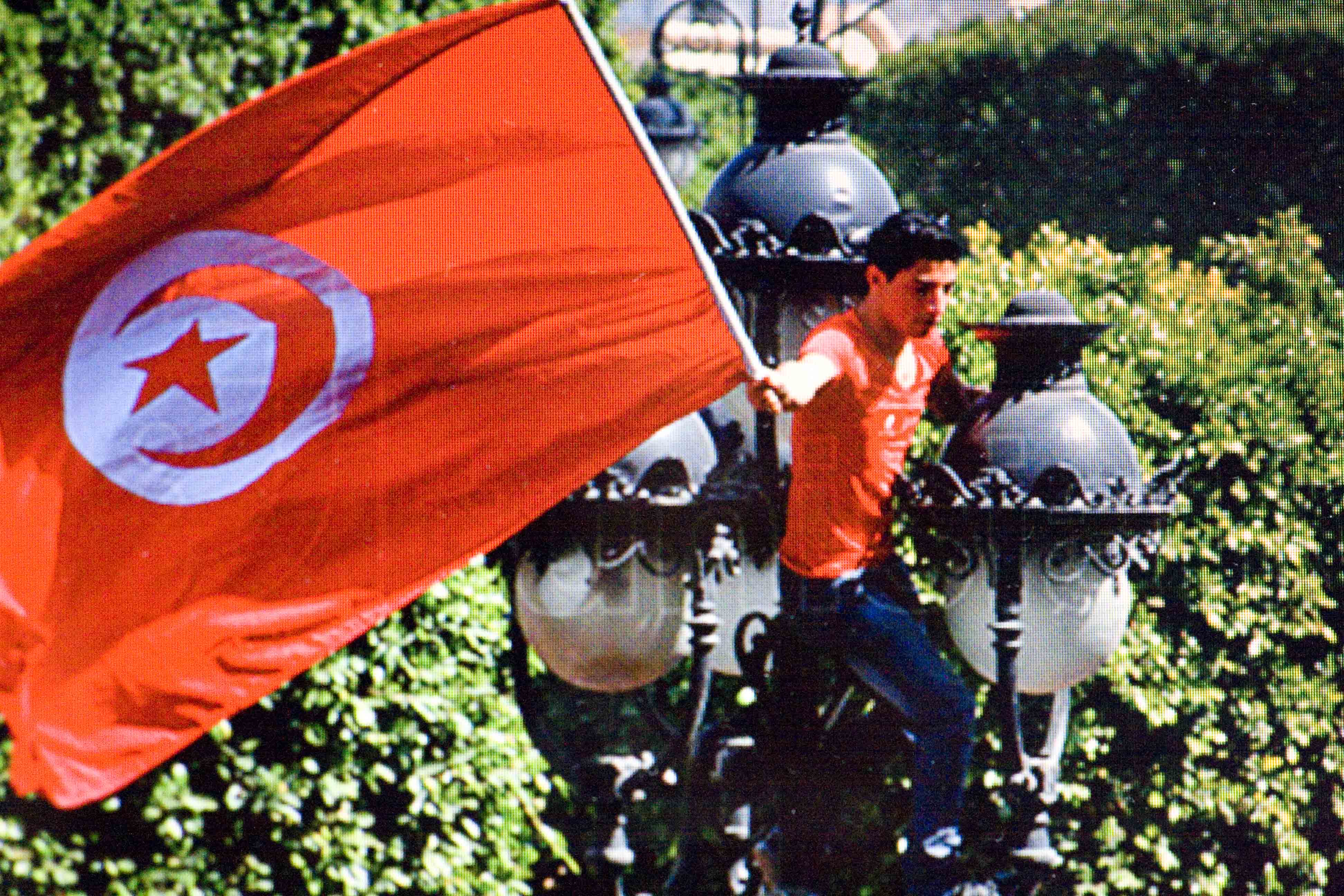 一位年輕人揮舞著突尼西亞國旗(網路圖片翻攝)