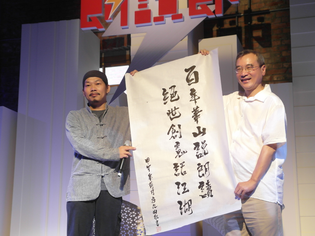 作詞人方文山(左)讓舊的文學語言成功結合流行音樂,今日在記者會中以「百年華山說朗讀,絕世創意話江湖」贈華山主人王榮文(右)。(記者陳淑貞攝)