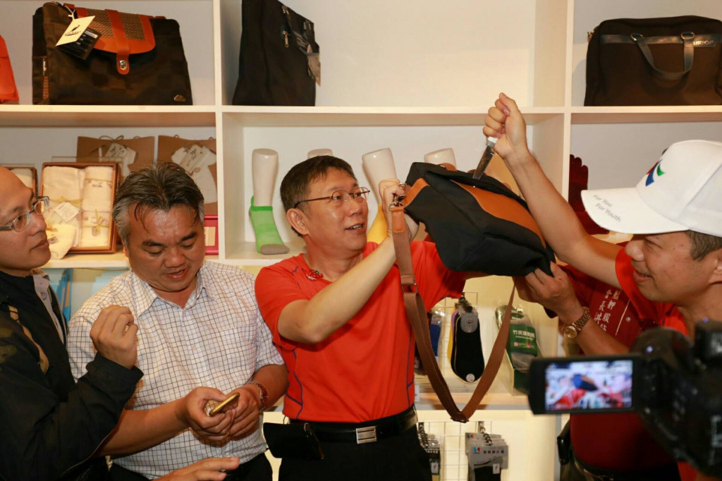 台北市長柯文哲上午到萬華以加健走及台灣製MIT微笑標章產品展售會，在現場用小刀測試防刀刺布料，媒體問防砍包、防砍外套，柯文哲是否有興趣採買。柯則盛讚是台灣紡織業的成就。圖／北市府
