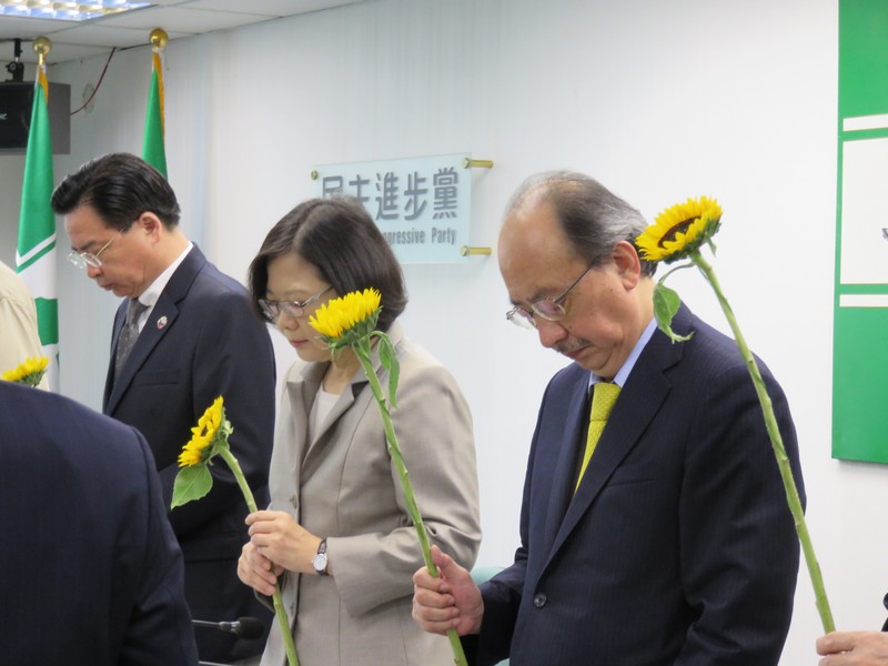 民進黨中常委手持太陽花,感念梅心怡對台灣民主貢獻。