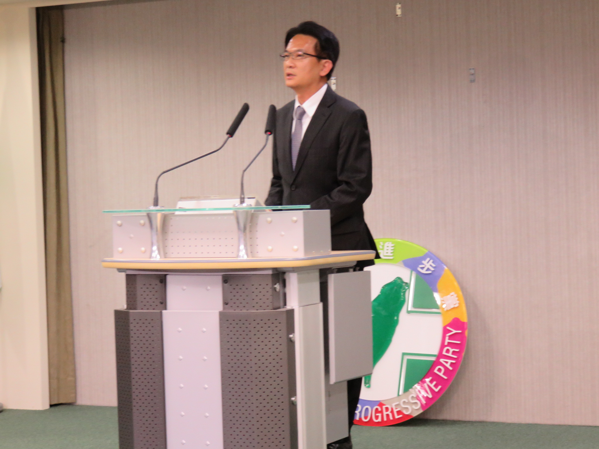 林俊憲講到選情冷，黨徽突然掉下來。（朱蒲青攝）