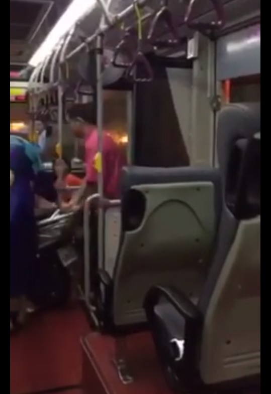 網友俞蕾拉所攝影片中，這名身穿紅色上衣的公車司機救起一名被颱風吹倒的機車騎士，連人帶車載上公車，讓網友感動狂按讚。（翻攝自網友臉書）20150928