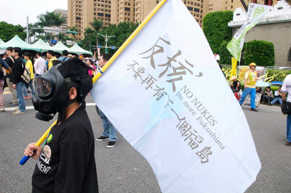 反核民眾手舉福島警示旗，頭戴防毒面具。(記者黃謙賢攝)