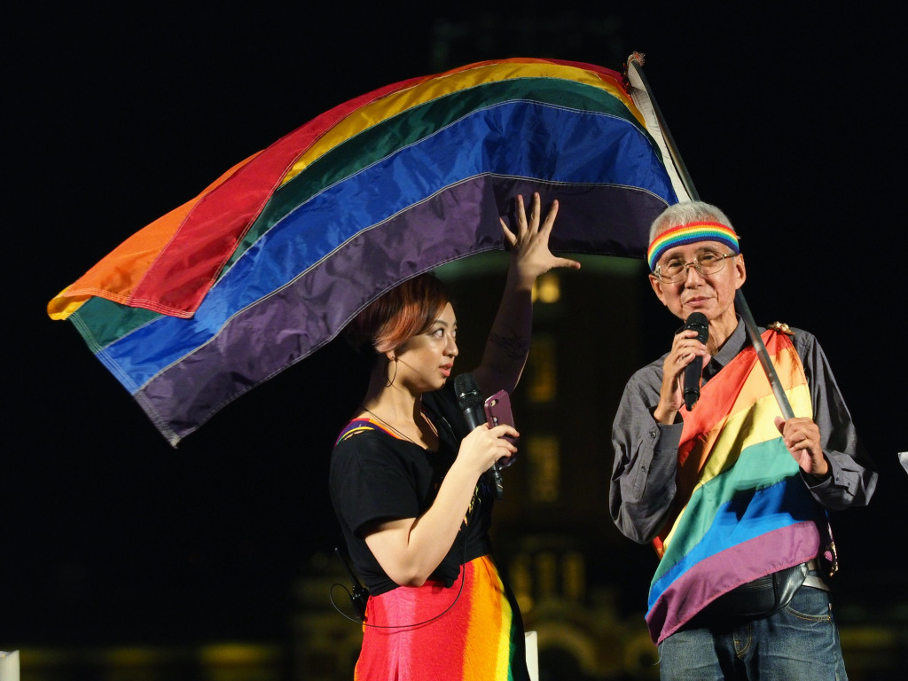 畢安生逝世週年的紀念晚會上，台灣同志運動先驅祁家威披著彩虹旗出席，帶領群眾高喊口號，呼籲政府不要再讓同性伴侶權益被剝奪，別讓悲劇再次發生。圖／張家銘