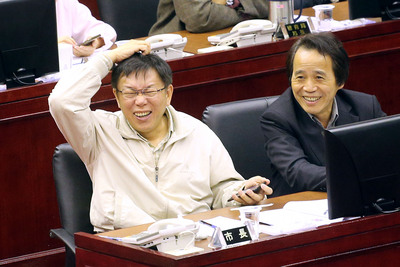 柯文哲第一天面對議會震撼教育，竟是不停搔頭、傻笑，看起來還滿開心的。（中央社）