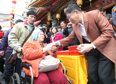 台北市長柯文哲（右）20日大年初二前往松山慈祐宮上香為市民祈福，並發送福袋。(中央社)