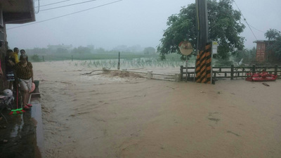 北海岸今天持續降下大雨，部分路段封閉，金山區三界壇路大淹水。(圖/中央社)