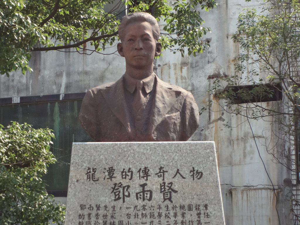 立在龍潭大池旁的鄧雨賢塑像，略顯斑駁。（劉明堂攝）