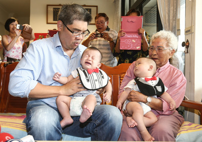 國民黨台北市長參選人連勝文(前左)2日拜訪高齡112歲的葉楊美芬奶奶(前右),和奶奶的雙胞胎曾孫互動,不過小朋友怕生哭了起來。(中央社)