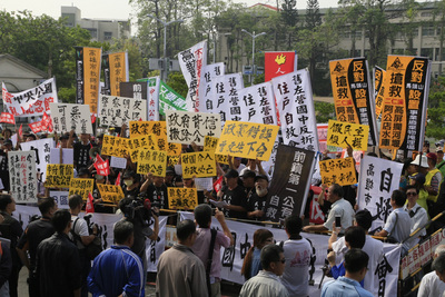 高雄市議會定期大會17日由市政做施政報告及質詢，一早議會就湧入數個抗議團體，數百民眾舉牌、拉布條抗議市府很多決策鴨霸、漠視弱勢聲音，民眾指陳菊於「民主社會搞權謀」等。圖／中央社