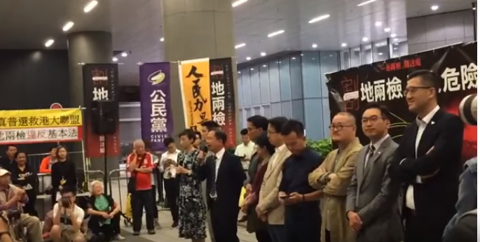 百名港人今（18）上街抗議一地兩檢，痛批港府黑箱作業，出賣香港形同割地。（圖為日前一地兩檢關注組抗議行動）。圖／擷取自《852郵報》影片畫面