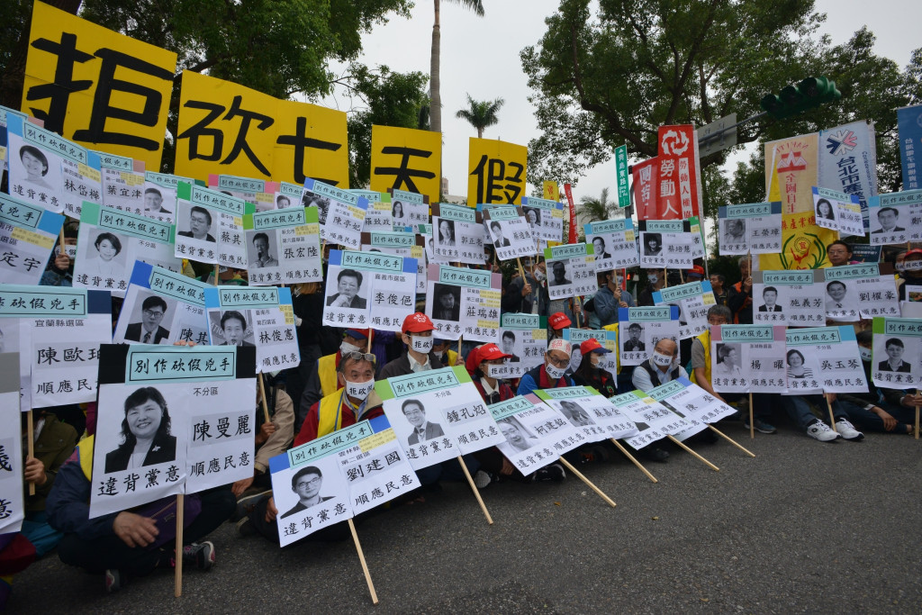 民進黨團總召柯建銘今天在警政署長陳國恩護送下進入議場，但立法院外勞團舉出68 位民進黨立委圖像要求罷免。 圖／郭文宏