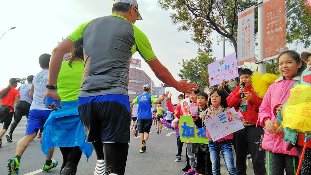 以「台灣最友善城市」為目標的2017高雄MIZUNO國際馬拉松今12日起跑，適逢學生寒假最後一天，學校學生也都起個大早在全市路跑沿線為參賽選手加油！參賽選手伸出友善之手與學生相互打氣！(記者陳俊廷攝)