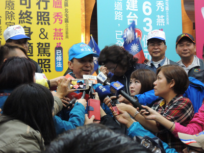 國民黨總統候選人朱立倫（左）11日到台中市冒雨陪同黨籍立委候選人車隊掃街，朱立倫向支持者喊話，風雨生信心，一定全力以赴。（中央社）